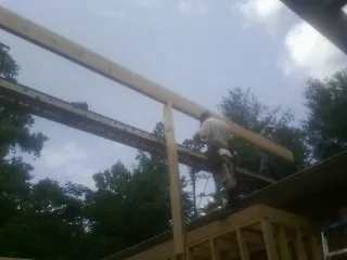 Carpenter setting a ridge beam over a new addition frame — Ice Dam Removal by Roofing Brothers in Hallsville