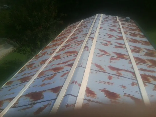 Rusted metal roof panels with new wood purlins before replacement — Storm Damage Roof Repair in Hallsville by Roofing Brothers